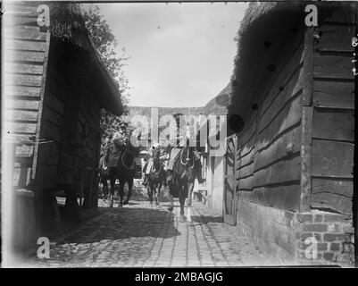 Royal Oak Inn, Wootton Rivers, Wiltshire, 1923. Eine Gruppe von Soldaten, die auf dem Pferderücken sitzen und den Eingang zum Innenhof des Royal Oak Inn verlassen. Auf der linken Seite des Fotos scheint ein Kornspeicher auf Holzsteinen zu sein. Stockfoto