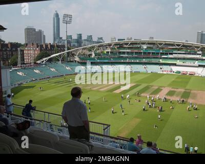 The Oval Cricket Ground, Kennington, Lambeth, Greater London Authority, 2013. Der OCS-Stand des Oval Cricket Ground, Kennington, vom Pavillon im Südosten aus gesehen, mit Besuchern auf dem Platz unten. Der OCS-Stand wurde im Rahmen der Neugestaltung des Vauxhall-Endes des Oval Cricket Grounds in den Jahren 2002-2005 errichtet. Der Einzelständer ersetzt die Surridge-, Fender-, Jardine- und Peter May-Stände. Stockfoto