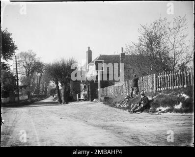 Russell Arms, Chalkshire Road, Butler's Cross, Ellesborough, Wycombe, Buckinghamshire, 1910. Ein Blick auf die Russell Arms vom Süden mit zwei Männern auf einem Ufer neben der Straße, einer sitzend und der andere mit Blick über einen Zaun zum Pub. Stockfoto