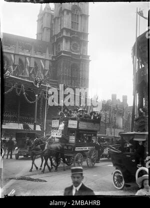 Westminster Abbey, Westminster, City of Westminster, Greater London Authority, 1911. Eine große Tribüne vor der Westminster Abbey zur Krönung von König George V und Königin Mary und ein Pferdebus mit „Krönungsroute“, der mit beladenen Passagieren vorbeifährt. Die Krönungsdekoration in London. Die große Tribüne, dekoriert mit Flöten, war eine von mehr als fünfzig errichtet entlang der Strecke zur Krönung von König George V. und Königin Mary am 22. Juni 1911. Stockfoto