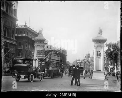 Whitehall, City of Westminster, Greater London Authority, 1911. Ein Blick auf zwei Säulen, die von Statuen vor dem Kabinett und der Schatzkammer in Whitehall übersät sind, mit Verkehr und Fußgängern auf der Straße. Die Krönungsdekoration in London. Der Fotograf bezeichnet die Säulen als „Ontario Pillars“, wahrscheinlich weil „Ontario“ oben in den Spalten erscheint, aber Postkarten der damaligen Zeit bezeichnen sie als „kanadische Säule“. Die Säulen wurden zur Feier der Krönung von König George V. und Königin Mary am 22. Juni 1911 errichtet. Stockfoto