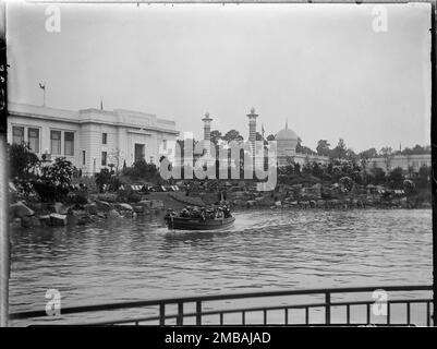 Wembley Park, Brent, Greater London Authority, 1924. Ein Boot voller Menschen auf dem See bei der British Empire Exhibition im Wembley Park, mit dem Australia Pavilion auf der linken Seite und dem Malaya Pavilion in der Ferne. Die British Empire Exhibition wurde am St. George's Day 1924 eröffnet, um den Handel anzuregen und die Beziehungen zwischen den Ländern des Britischen Empire zu stärken. Stockfoto