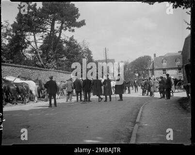 Fosse Way, Stow-on-the-Wold, Cotswold, Gloucestershire, 1928. Eine Gruppe von Männern, die Pferde in einem Zigeunerpferdverkauf auf der Hauptstraße der Stow Horse Fair anschauen. Das Unicorn Hotel an der Kreuzung der Sheep Street mit dem Fosse Way befindet sich auf der rechten Seite des Hintergrunds. Stockfoto