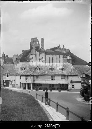 Greyhound Hotel, The Square, Corfe Castle, Purbeck, Dorset, 1927. Greyhound-Hotel mit den Ruinen von Corfe Castle auf dem dahinter liegenden Hügel, von Südosten aus gesehen vom Friedhof. Stockfoto