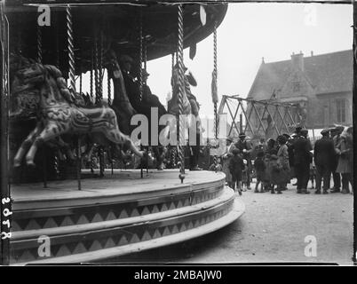 Market Square, Stow-on-the-Wold, Cotswold, Gloucestershire, 1928. Eine Vergnügungsmesse auf dem Marktplatz während der Stow Horse Fair, bei der sich eine Menschenmenge neben einem Kreisverkehr mit Schaukelbooten im Hintergrund versammelte. Stockfoto