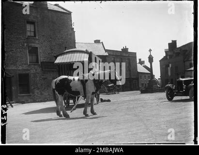 Market Square, Stow-on-the-Wold, Cotswold, Gloucestershire, 1928. Ein verdorbenes Pferd und ein Zigeunerkaravan, der auf der Stow Horse Fair in der Nähe des Marktkreuzes auf dem Marktplatz steht. Stockfoto