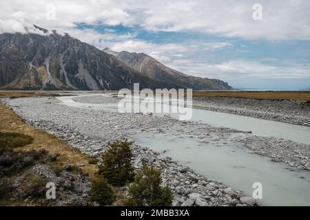 Der Hooker River fließt in Richtung des Tasman River in der Nähe von Mount Cook auf der Südinsel Neuseelands mit Bergen im Hintergrund Stockfoto