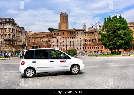 Rom, Italien - 10. Juni 2016: Taxifahrer auf einer belebten Straße mit Fußgängern und mit antiker römischer Architektur gesäumt. Stockfoto