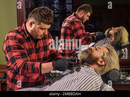 Machen Haare magisch aussehen. Männliche Schönheit und Mode. Reifer Mann im Friseursalon. Brutal bärtigen Mann beim Friseur. Friseur mit männlichen Kunden. Hipster mit Stockfoto