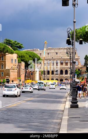 Rom, Italien - 10. Juni 2016: Geschäftige Straße voller Fußgänger in Rom, die zum Wahrzeichen Kolosseum in Italien führt. Stockfoto