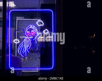 Vape Shop elektronische Zigarette Neonfarbene Fenster mit Anzeigeschildern leuchten auf, um Gäste nachts auf der Straße anzulocken. Concept Vape Shop. Stockfoto