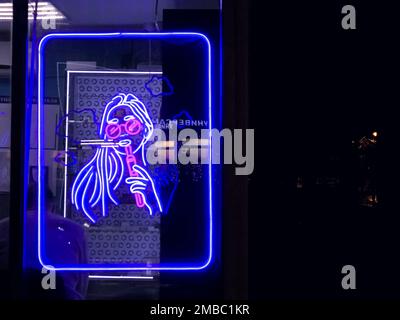 Vape Shop elektronische Zigarette Neonfarbene Fenster mit Anzeigeschildern leuchten auf, um Gäste nachts auf der Straße anzulocken. Concept Vape Shop. Stockfoto