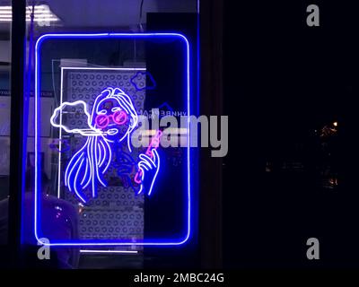 Vape Shop elektronische Zigarette Neonfarbene Fenster mit Anzeigeschildern leuchten auf, um Gäste nachts auf der Straße anzulocken. Concept Vape Shop. Stockfoto