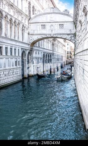 Venedig, Italien - 13. Juni 2016: Touristen machen eine Gondoliere-Fahrt durch die engen Wasserkanäle der Stadt Venedig. Stockfoto