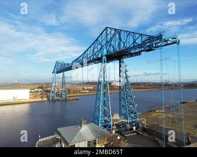 Ein Drohnenschuss von Tees-Transporterbrücke über dem Meer in einem Hafen unter blauem, wolkigen Himmel Stockfoto