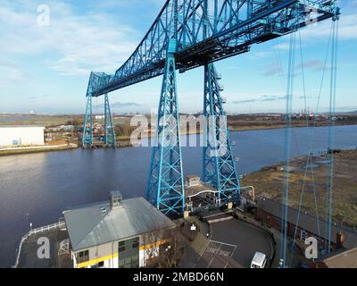 Ein Drohnenschuss von Tees-Transporterbrücke über dem Meer in einem Hafen unter blauem, wolkigen Himmel Stockfoto