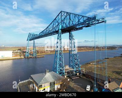 Ein Drohnenschuss von Tees-Transporterbrücke über dem Meer in einem Hafen unter blauem, wolkigen Himmel Stockfoto