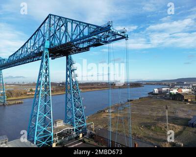 Ein Drohnenschuss von Tees-Transporterbrücke über dem Meer in einem Hafen unter blauem, wolkigen Himmel Stockfoto