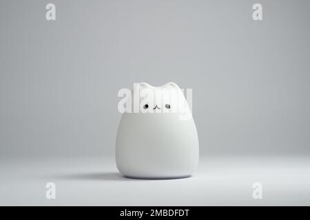 Weiße katzenförmige Lampe auf weißem Hintergrund. Niedliche katzenförmige Silikonlampe auf weißem Hintergrund. Stockfoto