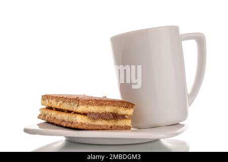 Ein Mini-Kakaokeks auf weißer Keramikuntertasse mit weißem Becher, Makro isoliert auf weißem Hintergrund. Stockfoto