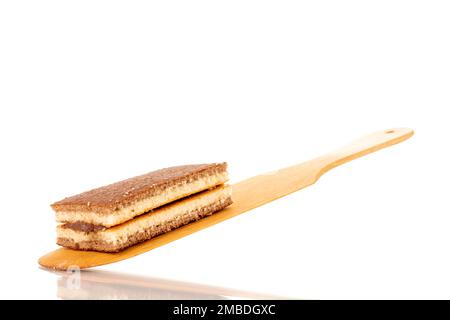 Ein Mini-Kakaokeks auf einem Holzlöffel, Makro, isoliert auf weißem Hintergrund. Stockfoto