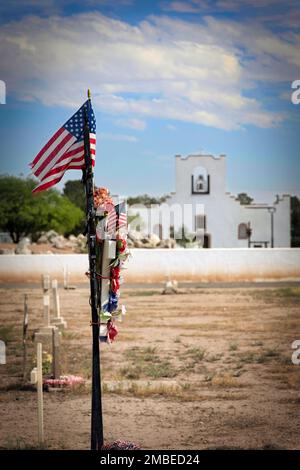 Eine amerikanische Flagge weht im Wind auf einem Friedhof in Socorro, Texas. Stockfoto