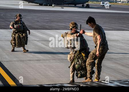 EIN US-AMERIKANISCHER Ein Fallschirmjäger der Armee hilft einem taktischen Offizier, an Bord eines C-17 Globemaster III zu gehen, der von der 176. Luftaufstandsschwadron auf der Joint Base Elmendorf-Richardson, Alaska, 15. Juni 2022 während DER RED FLAG-Alaska 22-2 entsandt wurde. Etwa 1.600 Mitglieder des Dienstes aus drei Ländern nehmen während dieser Übung am Fliegen, Warten und Unterstützen von mehr als 70 Flugzeugen aus über 22 Einheiten Teil. Die Fallschirmjäger sind dem 2. Infanterie-Brigaden-Kampfteam (Airborne), der 11. Luftwaffe und ST-Operatoren dem 23. Spezialtaktik-Geschwader, Hurlburt Field, Florida, zugeteilt. Stockfoto