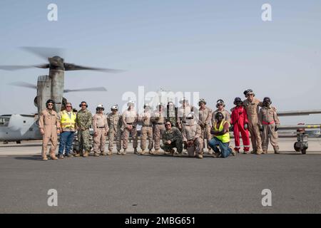 CAMP LEMONNIER, Dschibuti (15. Juni 2022) Militärpersonal, das dem Camp Lemonnier zugewiesen ist, Dschibuti (CLDJ), und Unterstützungspersonal von Auftragnehmern stehen für ein Porträt vor einem US-amerikanischen Marine Corps MV-22 Osprey mit Marine Medium Tiltrotor Squadron (VMM) 163 nach dem ersten heißen Tanken, einer Treibstoffauffüllungstechnik bei laufendem Motor eines Flugzeugs, die auf CLDJ durchgeführt wurde. Der Nachweis der Fähigkeit zum Heißbetanken in Dschibuti hat gezeigt, dass es möglich ist, die Betankungszeit um 66 Prozent zu verkürzen, was eine erhebliche Steigerung der Einsatzbereitschaft von Flugzeugen bedeutet. Stockfoto