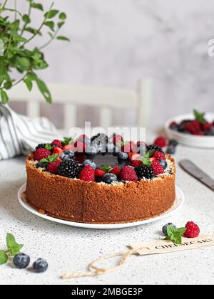Ein vertikaler Schuss hausgemachter Beeren Käsekuchen auf einem weißen Tisch Stockfoto