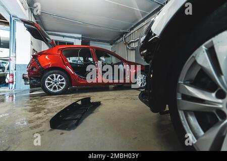Rote Autokarosserie in der Werkstatt, Hintergrundbild für die Halle. Hochwertiges Foto Stockfoto