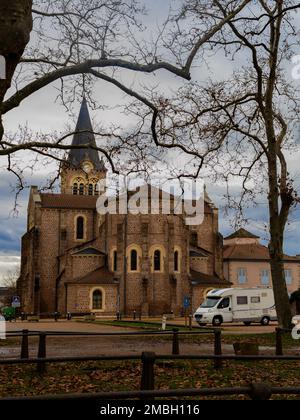 Wohnmobil vor der Kirche Saint-Jean-Baptiste de Lapalisse in Frankreich. Auvergne Rhone Alpes Region. Natürliches Framing. Reisen Sie mit dem Wohnmobil Stockfoto