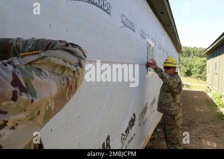 Army Reserve Staff Sgt. Ethan Cowell, Leiter des Baukommandos, 389. Engineer Company, verwendet eine Kreidelinie, um zu markieren, wo bei einem Bauprojekt in Fort McCoy, Wisconsin, am 16. Juni 2022 die Metallverkleidung geschraubt werden muss. Cowell und andere Ingenieure der 389. en. Co. Führt hier jährliche Schulungen durch und arbeitet während dieser Zeit an der Verbesserung der Schulungsbereiche. Stockfoto