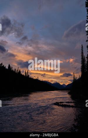 Am Rampart Creek Campground entlang des Icefields Parkway erwartet Sie ein atemberaubender Sonnenuntergang, der sich im nördlichen Saskatchewan River von Alberta widerspiegelt Stockfoto