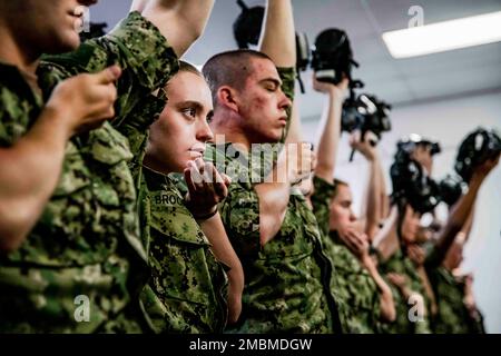 220617-N-PW480-0054 GREAT LAKES, ILLINOIS (17. Juni 2022) – Naval Reserve Officers Training Corps (NROTC) New Student Indoctrination (NSI) Midshipman Kandidaten halten ihre Gasmasken hoch, bevor sie die Vertrauenskammer beim Recruit Training Command (RTC) betreten, Juni 17. Nach Abschluss des NSI beginnen die Kandidaten in diesem Herbst ihr erstes Jahr des NROTC-Programms an Hochschulen und Universitäten im ganzen Land. NSI ist ein Indoktrinierungsprogramm, das bei RTC ausgerichtet wird und den Fähnrich-Fähnrich eine gemeinsame militärische Ausbildung vermittelt. NSI bietet Grundausbildung in fünf Grundlagen der Kriegsführung an – Feuergefecht Stockfoto