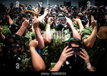 220617-N-PW480-0016 GREAT LAKES, ILLINOIS (17. Juni 2022) – Naval Reserve Officers Training Corps (NROTC) New Student Indoctrination (NSI) Midshipman Kandidaten testen die Passform ihrer Gasmasken vor dem Betreten der Vertrauenskammer auf Recruit Training Command (RTC), Juni 17. Nach Abschluss des NSI beginnen die Kandidaten in diesem Herbst ihr erstes Jahr des NROTC-Programms an Hochschulen und Universitäten im ganzen Land. NSI ist ein Indoktrinierungsprogramm, das bei RTC ausgerichtet wird und den Fähnrich-Fähnrich eine gemeinsame militärische Ausbildung vermittelt. NSI bietet Grundausbildung in fünf Grundlagen der Kriegsführung – Feuer Stockfoto