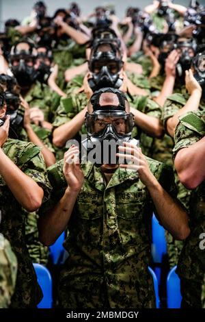 220617-N-PW480-0020 GREAT LAKES, ILLINOIS (17. Juni 2022) – Naval Reserve Officers Training Corps (NROTC) New Student Indoctrination (NSI) Midshipman Kandidaten testen die Passform ihrer Gasmasken vor dem Betreten der Vertrauenskammer auf Recruit Training Command (RTC), Juni 17. Nach Abschluss des NSI beginnen die Kandidaten in diesem Herbst ihr erstes Jahr des NROTC-Programms an Hochschulen und Universitäten im ganzen Land. NSI ist ein Indoktrinierungsprogramm, das bei RTC ausgerichtet wird und den Fähnrich-Fähnrich eine gemeinsame militärische Ausbildung vermittelt. NSI bietet Grundausbildung in fünf Grundlagen der Kriegsführung – Feuer Stockfoto