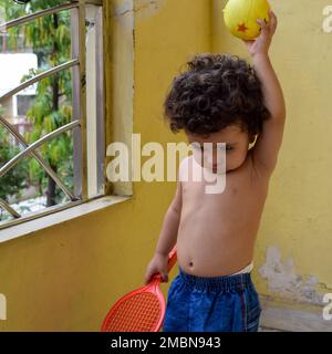 Süßer kleiner Junge Shivaay Sapra auf dem Balkon zu Hause im Sommer, süßer kleiner Junge Fotoshooting bei Tageslicht, kleiner Junge genießt zu Hause während Pho Stockfoto