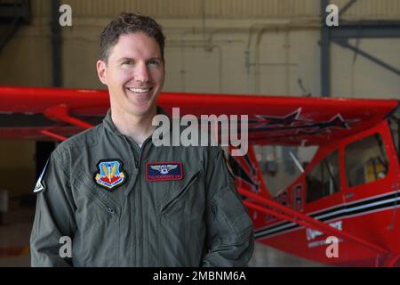 Michael Lents, Fluglehrer der University of North Dakota, posiert für ein Foto vor einem American Champion Aircraft 8KCAB Super Decathlon Demonstrationsflugzeug am 17. Juni 2022 in einem Flugzeug auf dem Luftwaffenstützpunkt Grand Forks, North Dakota. Lents trainiert das UND-Aerobatics-Team, wo er sein Team zu mehreren nationalen Collegiate-Titeln geführt hat. Stockfoto