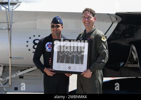 USA Air Force Major Jake Impellizzeriat, USA Air Force Demonstration Squadron „Thunderbirds“ Advance Pilot/Erzähler präsentiert Michael Lents, Fluglehrer der University of North Dakota, mit einer Thunderbirds Lithographie am 17. Juni 2022 auf dem Luftwaffenstützpunkt Grand Forks, North Dakota. Lents wurde als Held der Heimatstadt anerkannt und flog mit den Thunderbirds und erhielt nach dem Flug eine Lithographie. Stockfoto