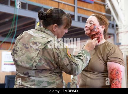 Sgt. 1. Klasse Kristina Boettcher vom 7306. Medizinischen Übungsbataillon in San Antonio, Texas, legt künstliche Wunden an Captain Melissa Doucette aus 1 kanadischen Feldlazarett Petawawa, Ontario, Kanada, in Fort Hunter Liggett, Kalifornien, am 18. Juni 2022 während Global Medic 22-01. Ein breites Spektrum an Militärpersonal aus verschiedenen Ländern versammelte sich, um für verschiedene medizinische Situationen zu trainieren und sich vorzubereiten. Stockfoto