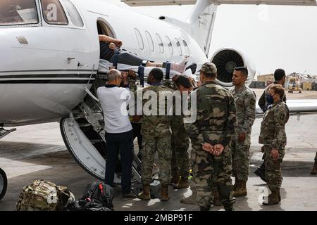 Eine Gruppe von Mitgliedern des Dienstes arbeitet als Team, um eine Trage zu heben, die ein ververletztes Mitglied des Dienstes in einem französischen Jet hält, um während der Übung zum Afrikanischen Löwen 22 am Hauptsitz der südlichen Zone in Agadir, Marokko, am 18. Juni 2022 evakuiert zu werden. Der afrikanische Löwe 2022 ist in den USA Die größte gemeinsame jährliche Übung des Kommandos Afrika, die von Marokko, Ghana, Senegal und Tunesien veranstaltet wird, vom 6. Bis 30. Juni. Mehr als 7.500 Teilnehmer aus 28 Ländern und der NATO trainieren zusammen mit dem Schwerpunkt auf der Verbesserung der Bereitschaft für US-Streitkräfte und Partner-Nationalstreitkräfte. AL22 ist eine gemeinsame, bereichsübergreifende, mehrteilige und multinationale Übung, die als Angestellter fungiert Stockfoto