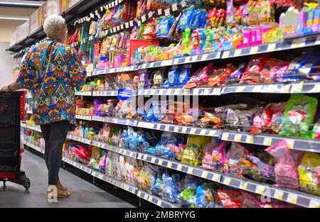 Farbenfrohes Afrika - eine Frau, die Lebensmittel auf einem Markt im Dorf Carrefour, Nairobi KE, einkauft Stockfoto