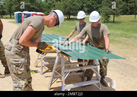 Soldaten der 389. Engineer Company des Army Reserve in des Moines, Iowa, arbeiten am 21. Juni 2022 an einem Truppenprojekt im Camp Courage auf der South Post in Fort McCoy, Wisconsin. Das Unternehmen arbeitete im Rahmen seiner jährlichen Schulung 2022 an mehreren Projekten zur Verbesserung des Lagers, einschließlich der Montage neuer Metallverkleidungen an zahlreichen Gebäuden. Die Truppenprojekte werden von der Direktion für öffentliche Arbeiten von Fort McCoy koordiniert und tragen zur Verbesserung der Infrastruktur der Anlage bei, während gleichzeitig die Ausbildung von Armeeingenieureinheiten stattfindet. Stockfoto