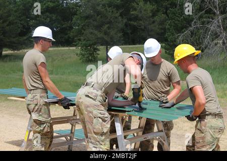 Soldaten der 389. Engineer Company des Army Reserve in des Moines, Iowa, arbeiten am 21. Juni 2022 an einem Truppenprojekt im Camp Courage auf der South Post in Fort McCoy, Wisconsin. Das Unternehmen arbeitete im Rahmen seiner jährlichen Schulung 2022 an mehreren Projekten zur Verbesserung des Lagers, einschließlich der Montage neuer Metallverkleidungen an zahlreichen Gebäuden. Die Truppenprojekte werden von der Direktion für öffentliche Arbeiten von Fort McCoy koordiniert und tragen zur Verbesserung der Infrastruktur der Anlage bei, während gleichzeitig die Ausbildung von Armeeingenieureinheiten stattfindet. Stockfoto