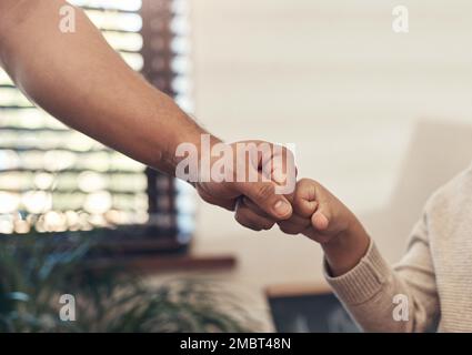 Ein Vater ist der beste Freund, den ein Junge haben kann. Ein nicht wiedererkennbarer kleiner Junge, der mit seinem Vater zu Hause Fäuste schlägt. Stockfoto