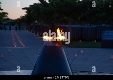 ITOMAN, Japan (22. Juni 2022) die Flamme des Grundsteins des Friedensdenkmals wird angezündet, während Kerzen den Okinawa Peace Memorial Park in Itoman, Okinawa, Japan, 22. Juni 2022 erleuchten. Die Kerzenbeleuchtung fand am Vorabend des Okinawa Memorial Day statt, einem Präfekturfeiertag zu Ehren derer, die während der Schlacht von Okinawa 1945 starben. USA Zu den Kerzenanzündern zählten Marinesoldaten von Commander, Fleet Activities Okinawa (CFAO) und Mieterkommandos. Der Friedenspark wurde auf dem Mabuni Hill erbaut, dem Ort des Endes der Schlacht und der aktuelle Ort der Gedenkmauern, die die mehr als 200.000 Toten benennen Stockfoto
