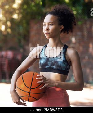 Auf der Suche nach neuen Herausforderern. Eine attraktive junge Sportlerin, die auf dem Basketballfeld steht. Stockfoto