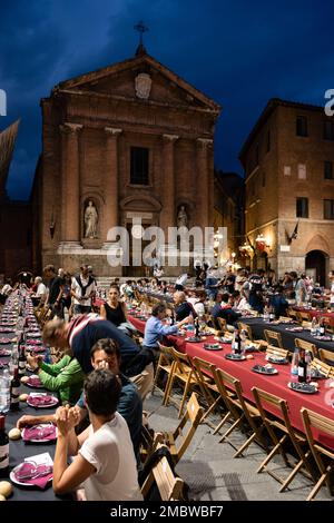 Siena, Italien - August 15 2022: Das große Contrada-Dinner der Civetta oder der kleinen Eule Contrada am Abend vor dem Palio dell Assunta auf der Piazza to Stockfoto