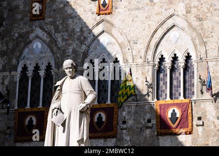 Siena, Italien - August 16 2022: Statue von Sallustio Bandini vor dem Palazzo Salimbeni in Siena, Italien, hergestellt von Tito Sarrocchi im Jahr 1880. Stockfoto