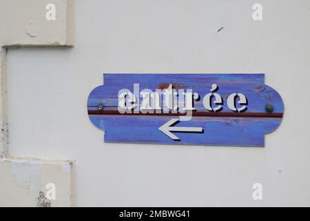 Ein blaues Schild mit einem Pfeil, der im französischen Text „Vorspeise“ anzeigt, bedeutet „Eingabe“ Stockfoto